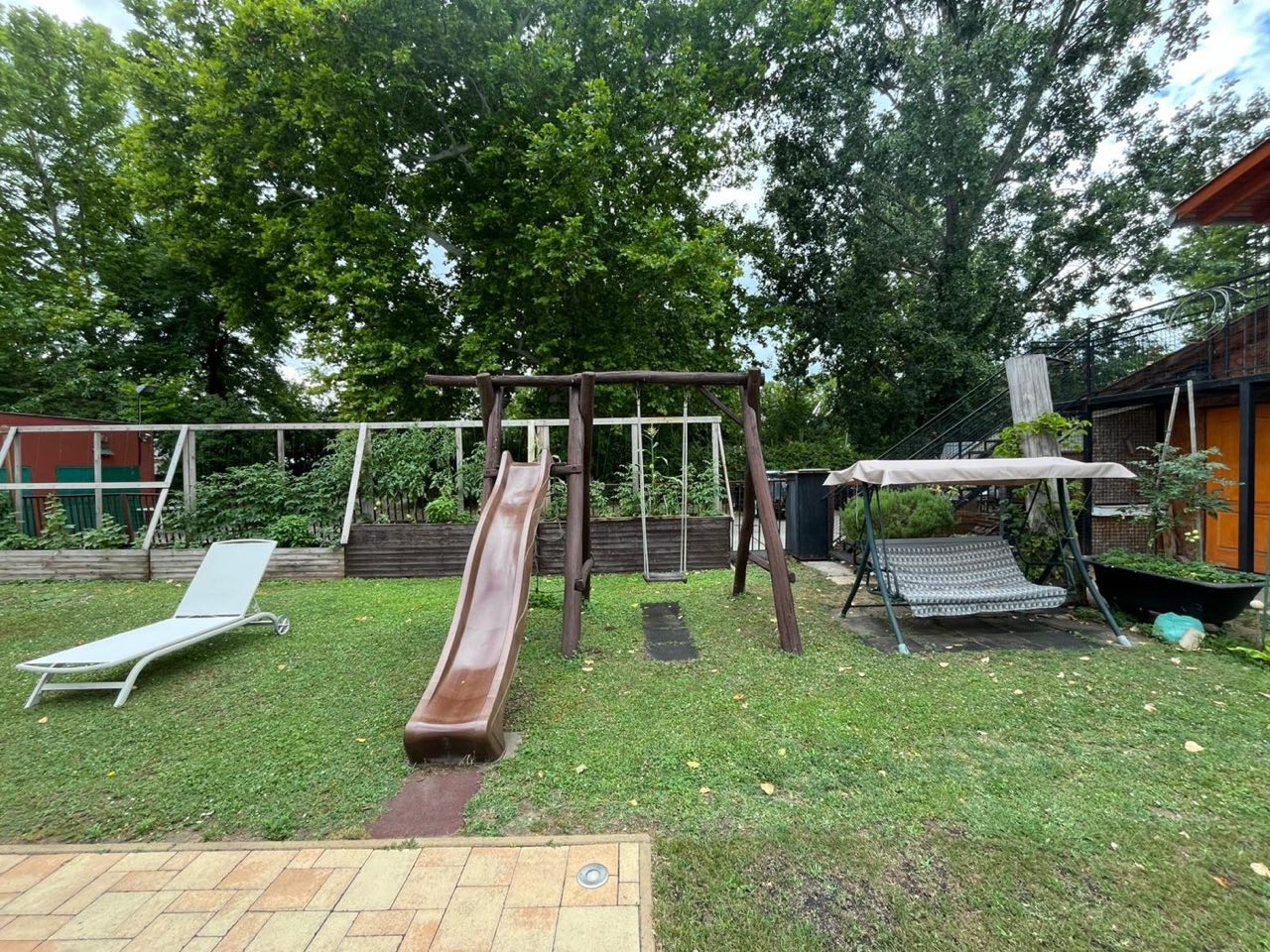 Spielplatz im Garten mit Rutsche und Schaukel für Kinder