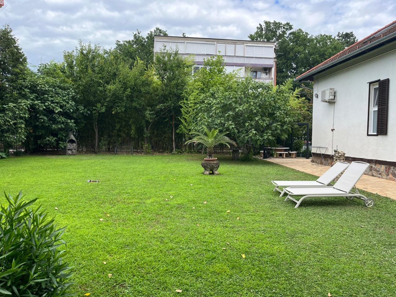 Panorama des großzügigen Gartens mit Sonnenliegen