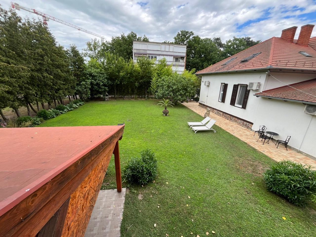 Garten mit gepflasterter Terrasse und Sonnenliege