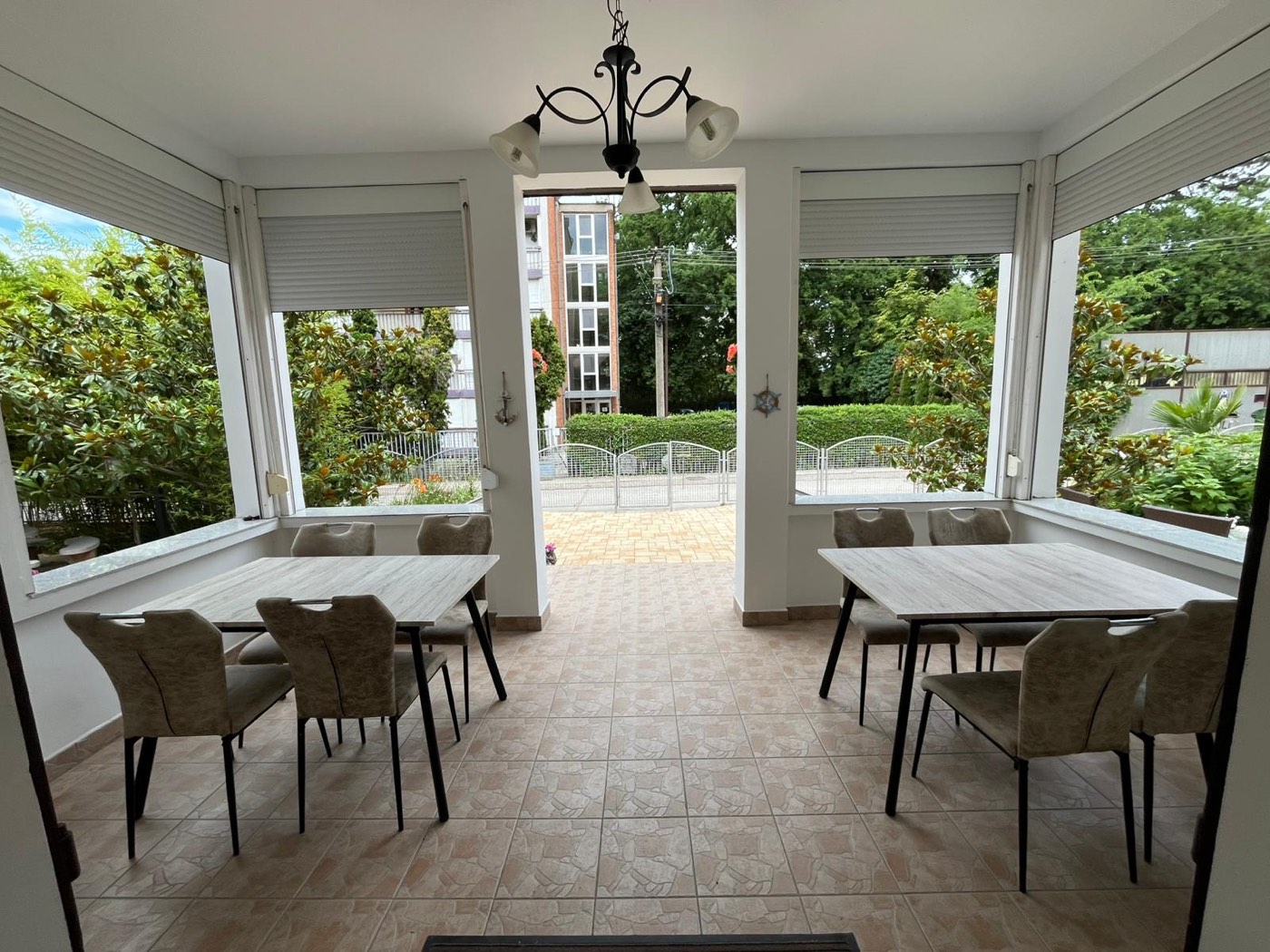 Gemeinsamer Essraum mit verglaster Veranda und Blick in den Garten
