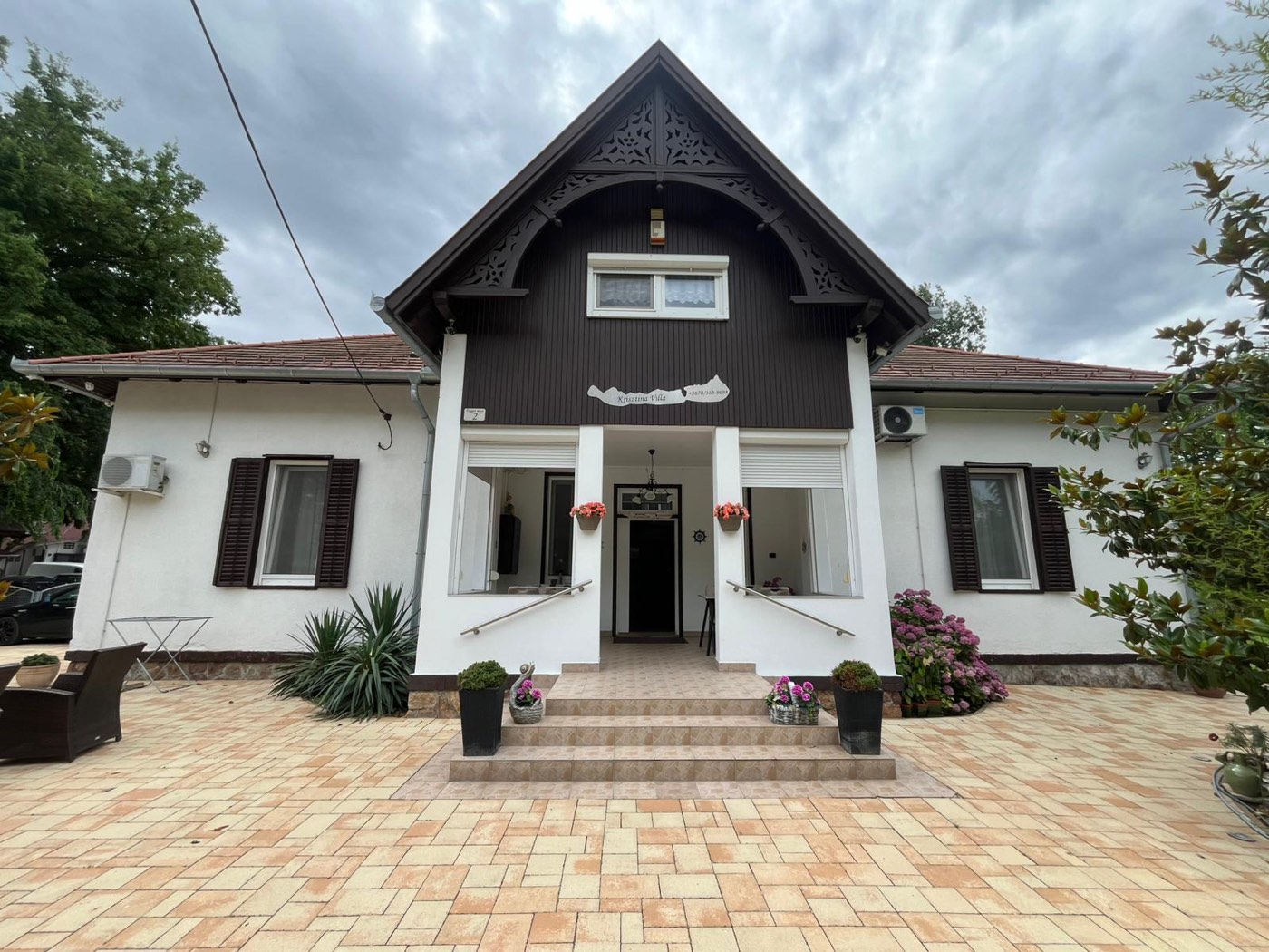 Fassade der Krisztina Villa in Balatonlelle mit blumengesäumtem Eingang